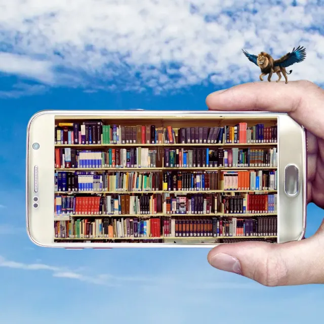 Hand hält ein Smartphone mit einem Bücherregal auf dem Display vor blauem Himmel, oben rechts ein geflügelter Löwe